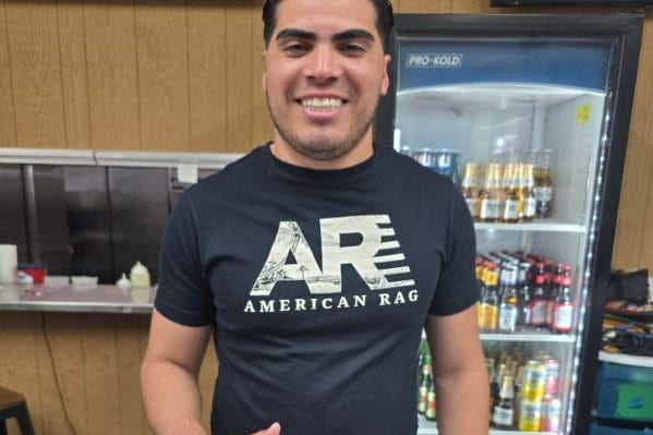 A team member at Alma Llanera Restaurant gives a thumbs up behind a new payment terminal