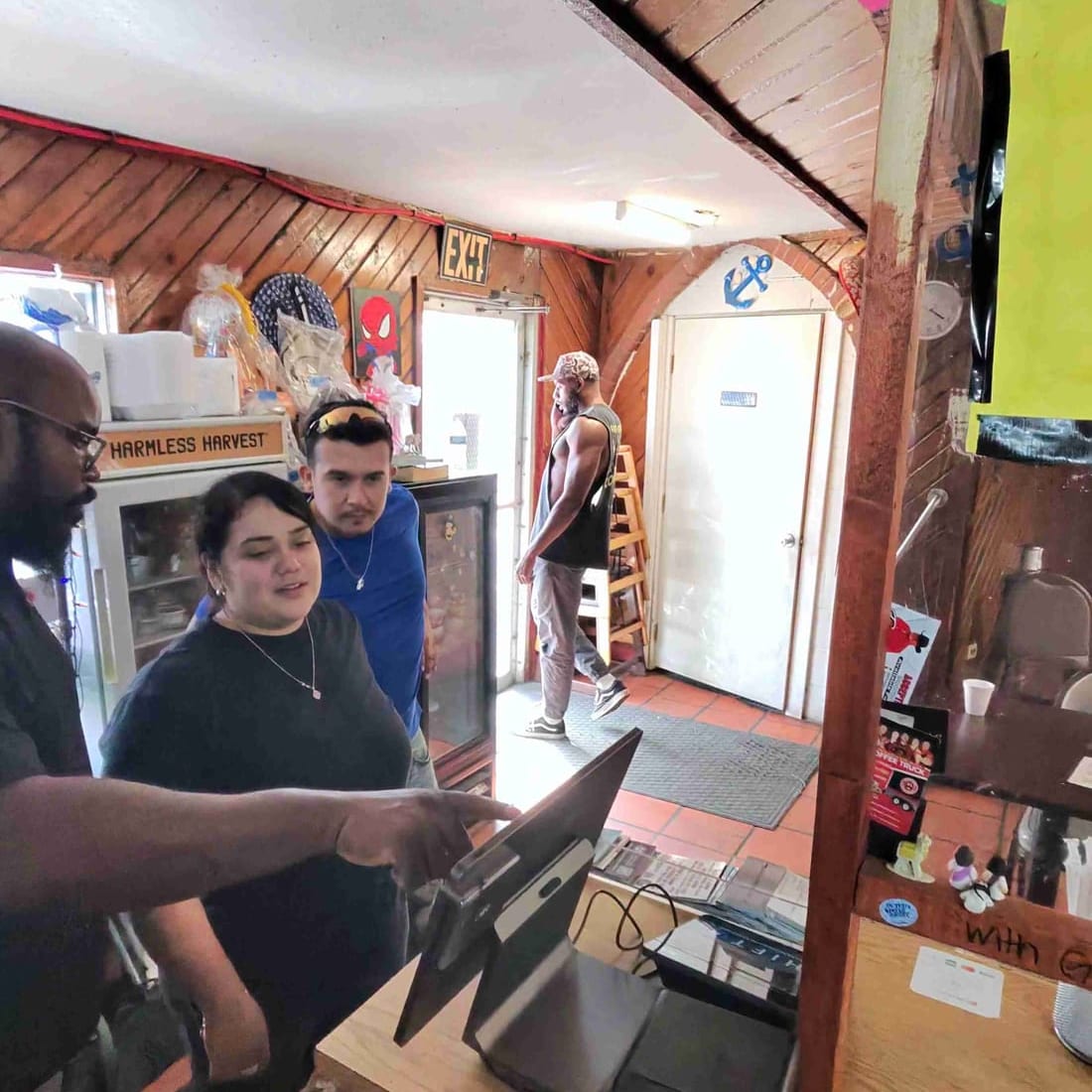 Restaurant staff gather around a new terminal during training