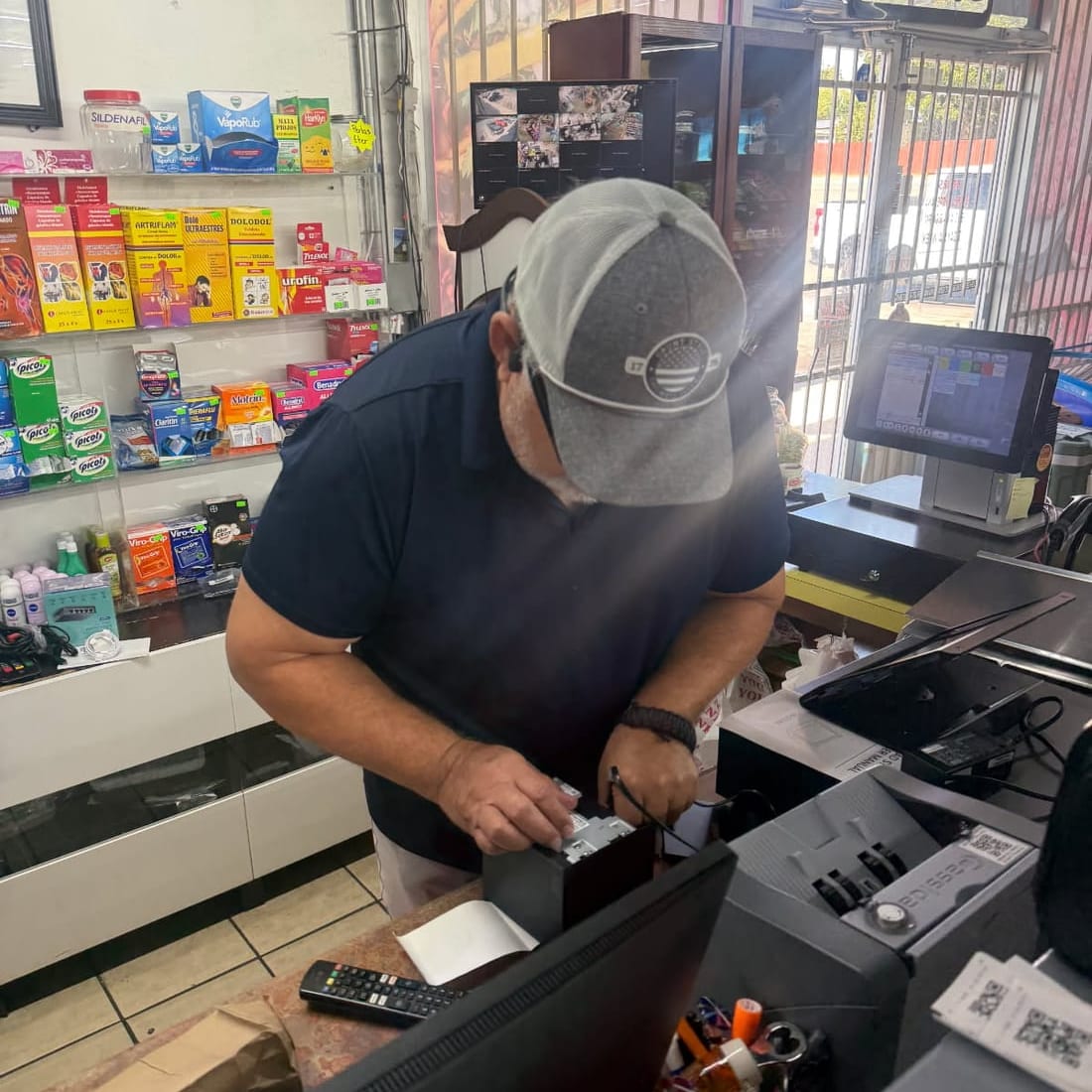 An installer connects a receipt printer at a store register